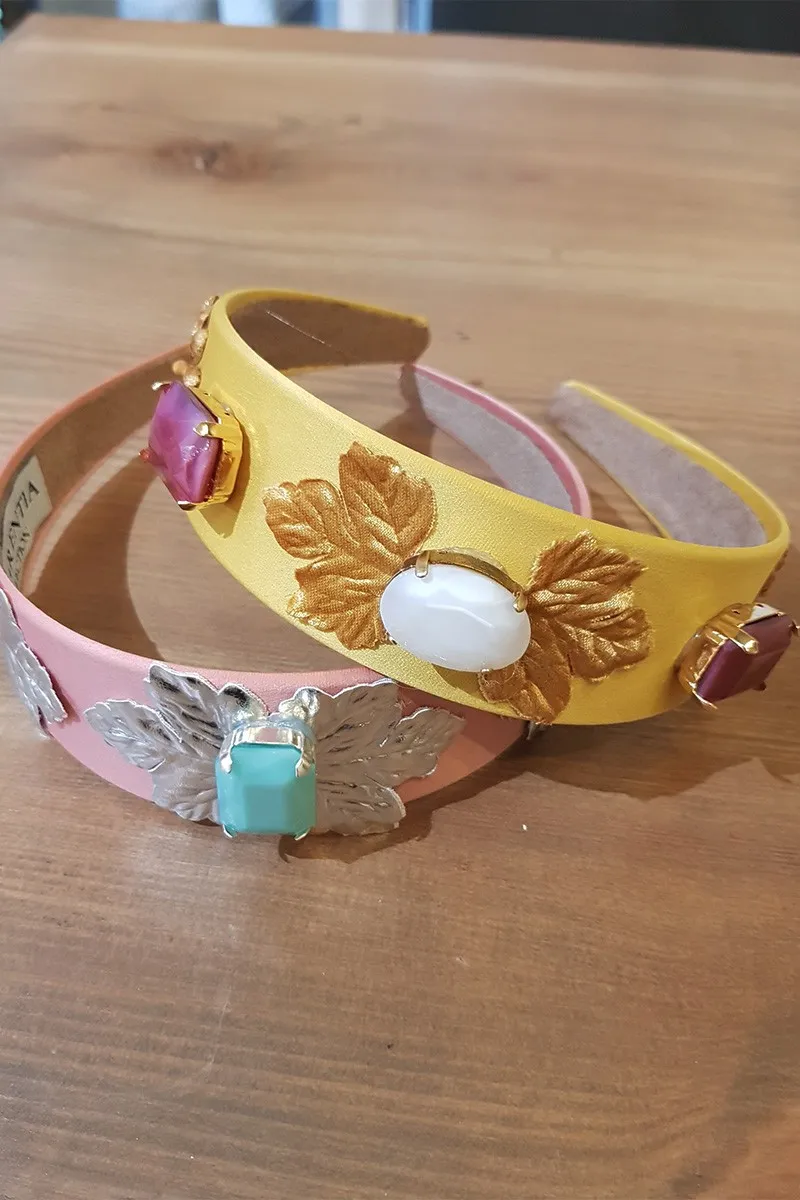 Diadema dorada con hojas y piedras facetadas blancas y frambuesas
