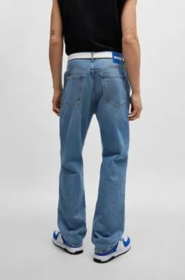 Vaqueros en denim azul medio con cinta de logos en la cintura