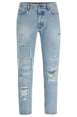Vaqueros tapered fit en denim azul con detalles desgastados