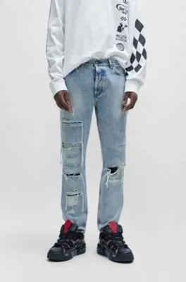 Vaqueros tapered fit en denim azul con detalles desgastados