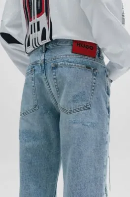 Vaqueros tapered fit en denim azul con detalles desgastados