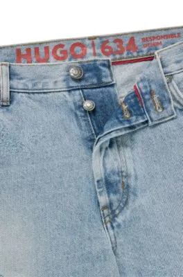 Vaqueros tapered fit en denim azul con detalles desgastados