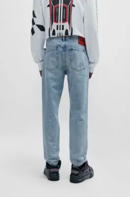 Vaqueros tapered fit en denim azul con detalles desgastados